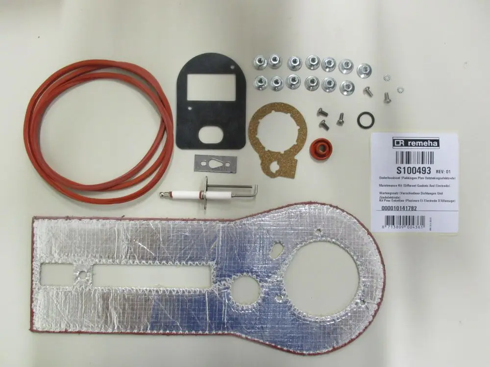 Wartungssatz mit verschiedenen Dichtungen, Schrauben, Elektrode und Gummi-Elementen von Remeha, geeignet für Kessel-Modelle. Teile auf hellem Untergrund angeordnet.